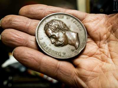 Nel frattempo ci indica una moneta in bronzo che celebra la visita di Re Umberto I agli appestati...